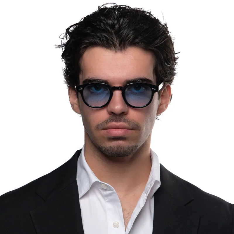 Homem com óculos Zadok Le Corbusier Black Blue de armação preta e lentes azuis.